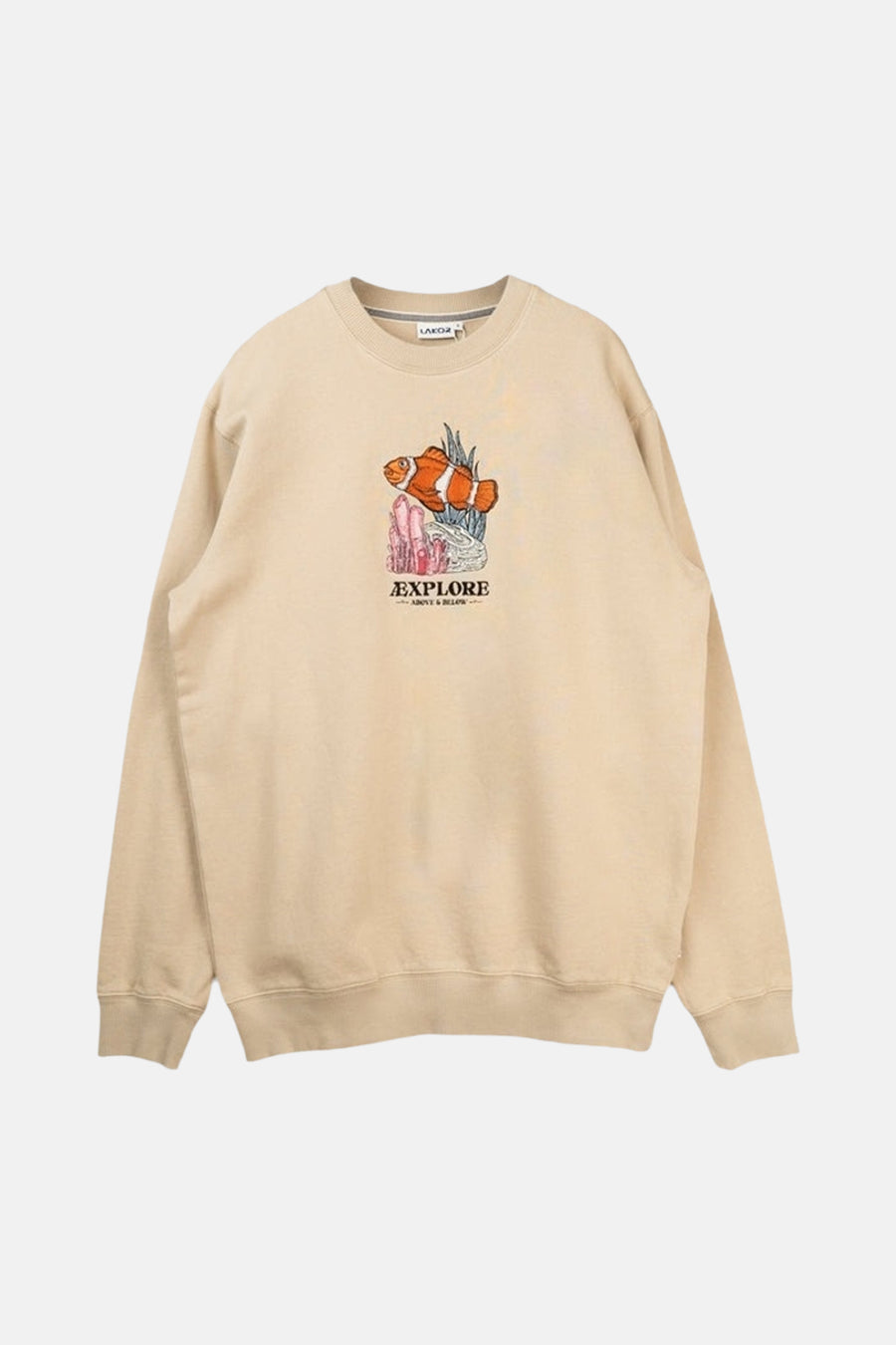 Pull écru de LAKOR, vu de dos, à manches longues et associé à un short vert et une casquette.