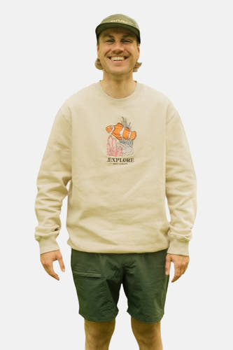 Pull écru de LAKOR, avec un imprimé graphique de poisson-clown et un short vert.