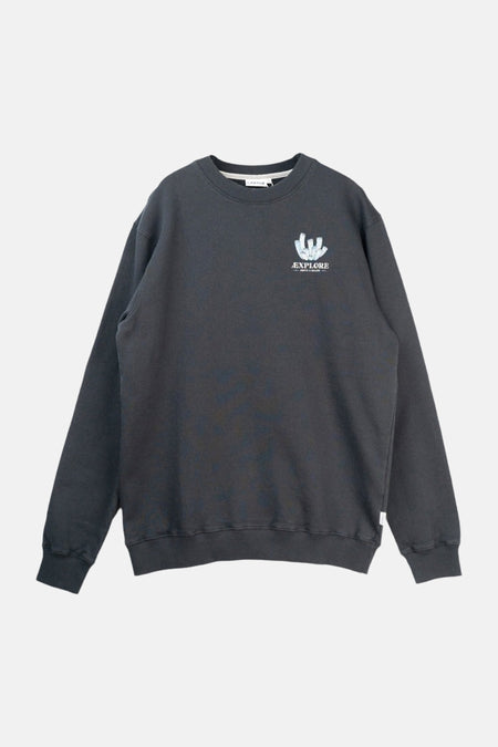 Sweat-shirt noir de LAKOR, avec un imprimé de récifs coralliens et le texte "Explore Above & Below" dans le dos, avec une casquette jaune.