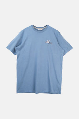 T-shirt bleu de LAKOR, avec un imprimé graphique d'un poisson volant dans un cadre ovale.