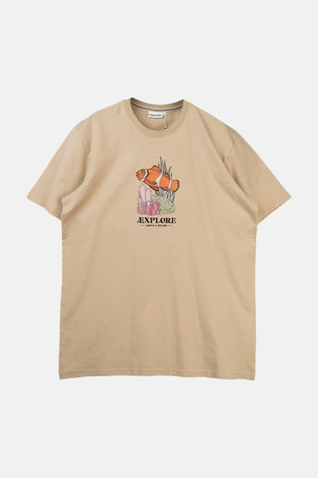 T-shirt beige de LAKOR, avec une image de poisson-clown et le texte "EXPLORE ABOVE & BELOW".
