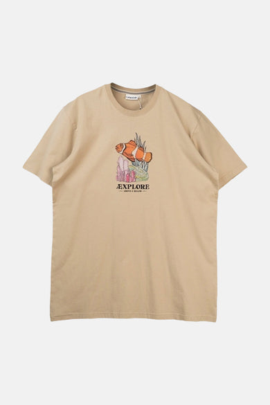 T-shirt beige de LAKOR, avec une image de poisson-clown et le texte "EXPLORE ABOVE & BELOW".
