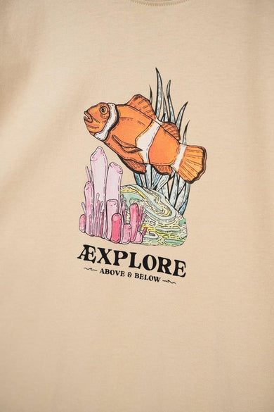 T-shirt beige de LAKOR avec imprimé de poisson-clown, corail et le texte "Explore Above & Below".