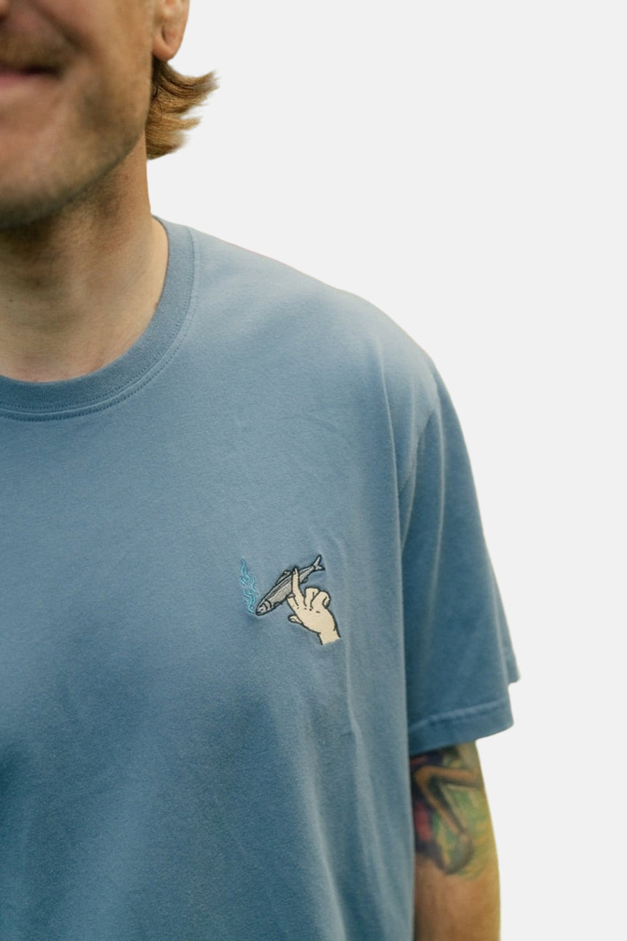 Blauw T-shirt met korte mouwen van LAKOR, met borduursel van een hand en vis.
