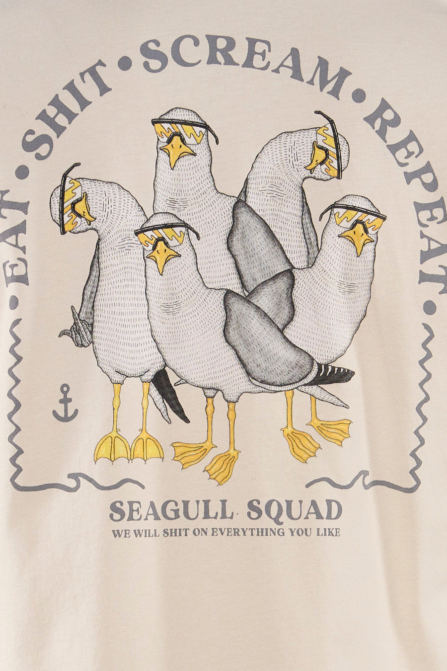 T-shirt écru de LAKOR avec un imprimé cartoon de mouettes portant des lunettes de soleil et le slogan 'SHIT • SCREAM • EAT • REPEAT' et 'SEAGULL SQUAD'.