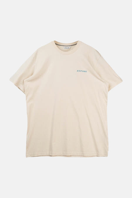 T-shirt écru de LAKOR avec un imprimé graphique d'un phoque sur une pierre pour une maison d'été.