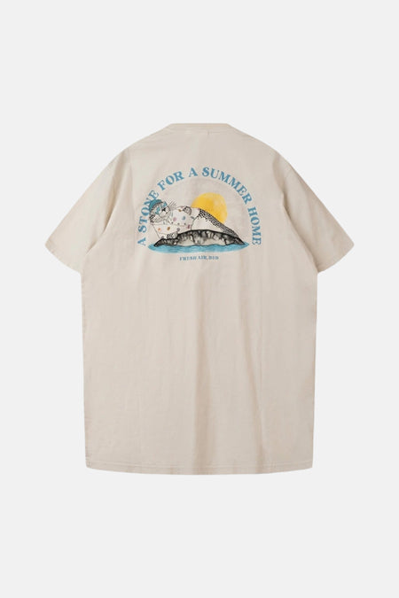 T-shirt écru de LAKOR, avec un imprimé de phoque et le texte 'A stone for a summer home' au dos.