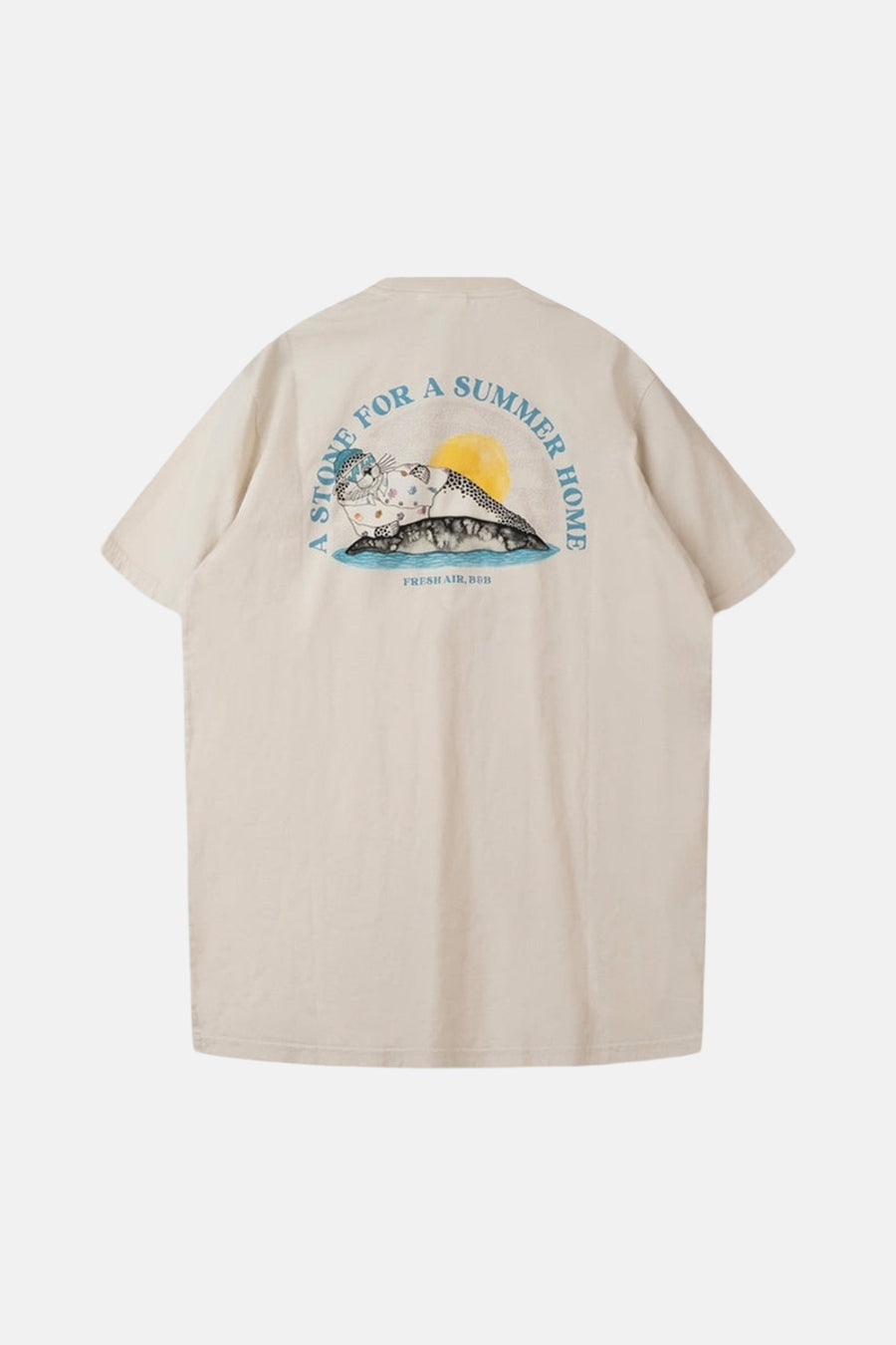 T-shirt écru de LAKOR, avec un imprimé de phoque et le texte 'A stone for a summer home' au dos.