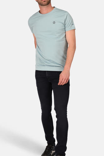 Jean slim de denim bleu-noir de Lee Cooper®, associé à un T-shirt bleu clair et des baskets.