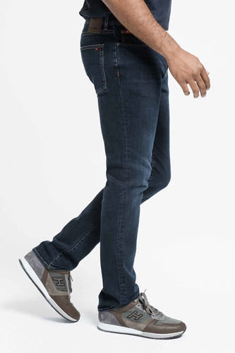 Jean droit bleu marine de Lee Cooper, porté par un modèle tailleur avec des baskets brunes.