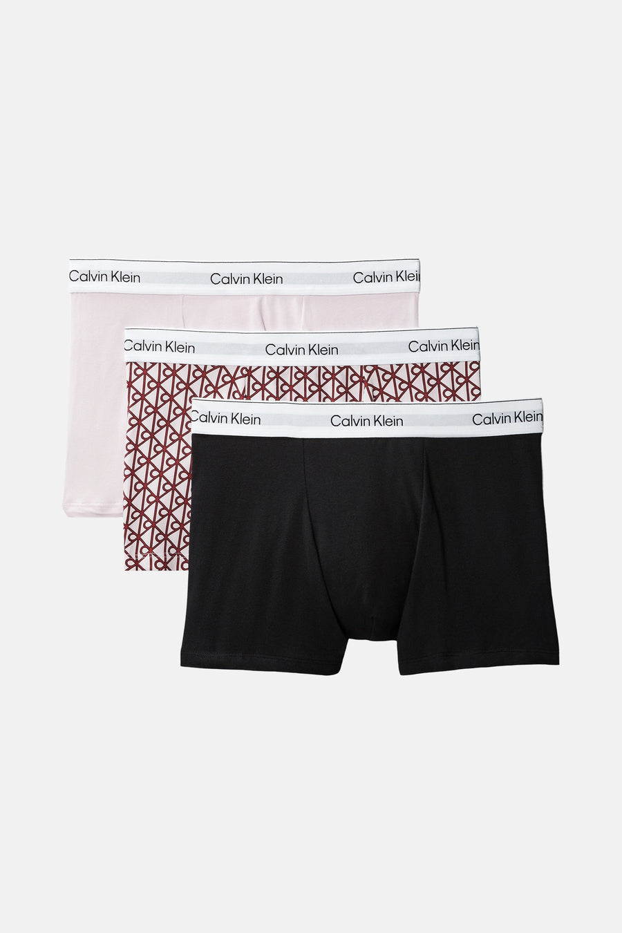 Boxershorts multicolores Calvin Klein à motif géométrique et ceinture logo blanche, portées par un homme.