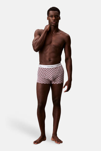 Boxer short multicolore de Calvin Klein avec motif géométrique rouge et ceinture blanche avec nom de marque.
