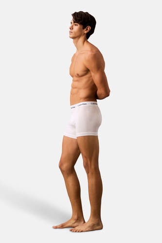 Slip blanc de Calvin Klein porté par un homme musclé en vue latérale.