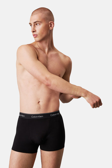 Boxer short noir Calvin Klein, porté par un mannequin masculin étirant son bras droit sur sa poitrine.