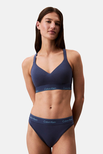 Manteau bleu de Calvin Klein, porté avec un short coordonné.