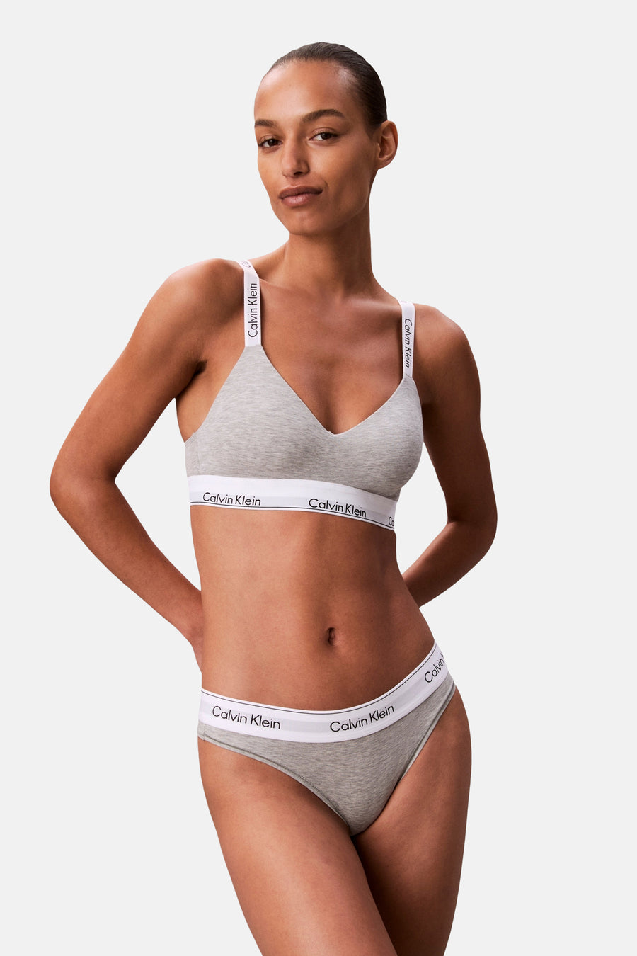 Grijze beha van Calvin Klein, met bandjes en rand met logo, gedragen door een model.
