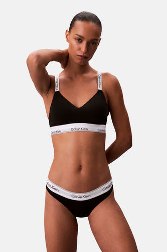Calvin Klein noir, porté par un modèle avec une culotte assortie sur un fond uni.