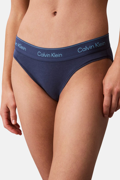 Jean bleu de Calvin Klein, avec une ceinture élastique et des détails de logo.
