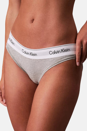 String gris de Calvin Klein, porté par un mannequin, avec une ceinture élastique à logo.