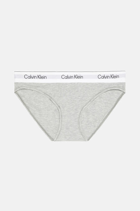 String gris Calvin Klein, avec une ceinture blanche à logo de la marque.