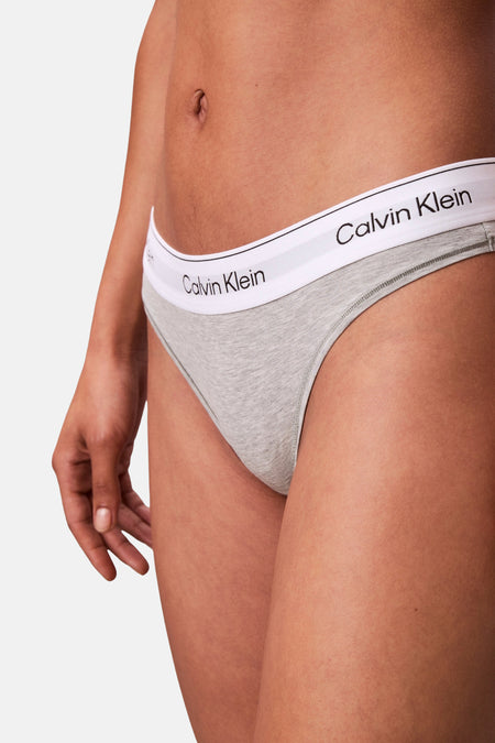 Grijze string van Calvin Klein, met witte band met logo op de voorkant, close-up vooraanzicht.
