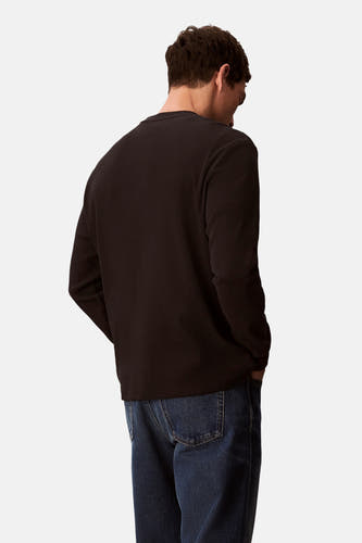 T-shirt noir à manches longues de Calvin Klein, vu de l'arrière, porté avec des jeans foncés.