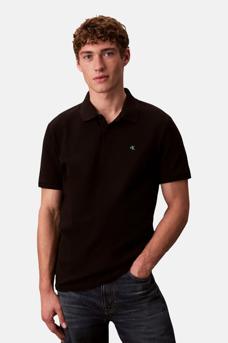 Polo noir à manches courtes de Calvin Klein, porté avec un jean foncé.
