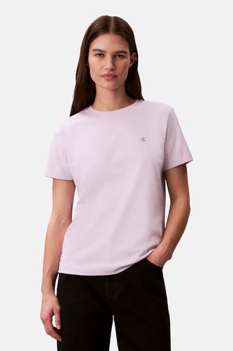 T-shirt à manches courtes violet de Calvin Klein, porté avec un pantalon noir et une ceinture.