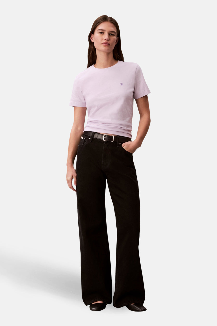 T-shirt à manches courtes violet de Calvin Klein, porté avec un pantalon noir et une ceinture.