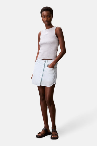 T-shirt à manches courtes gris Calvin Klein porté avec une jupe bleu clair et des sandales noires.