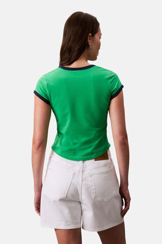 T-shirt vert de mantes courtes bras Calvin Calvin Klein, avec une vue arrière, avec un bord bleu marine et des short blancs.