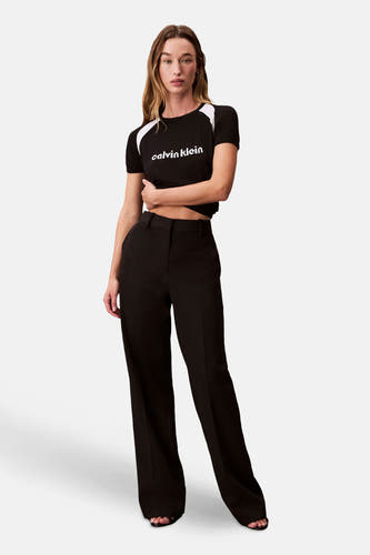 T-shirt noir à manches courtes de Calvin Klein, avec des accents blancs sur les épaules et le logo.