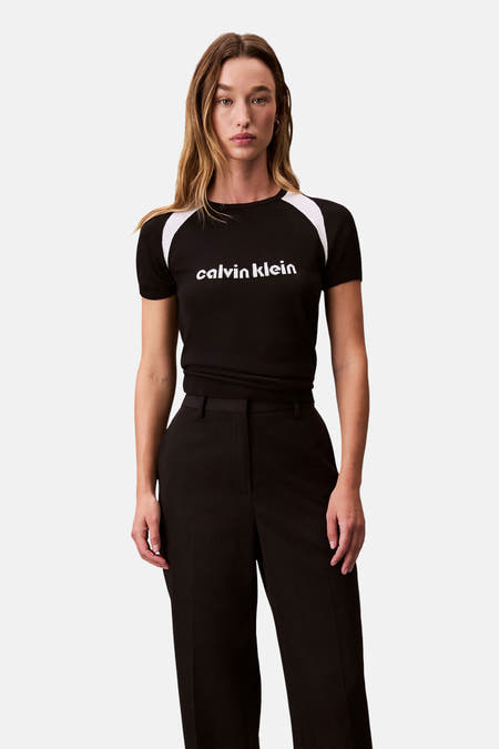 T-shirt noir à manches courtes de Calvin Klein, avec des accents blancs sur les épaules et le logo sur la poitrine.