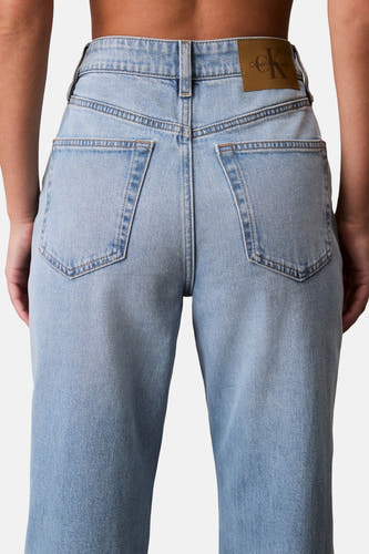 Jean droit en denim bleu clair de Calvin Klein, avec des poches arrière et un étiquette logo marron.