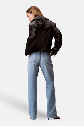 Jean droit bleu clair denim de Calvin Klein, dos, associé à une veste en cuir noire.