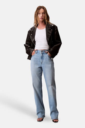 Jean droit en denim bleu clair de Calvin Klein, porté avec un t-shirt blanc et une veste en cuir noir.