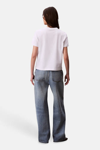 T-shirt blanc à manches courtes de Calvin Klein, vu de derrière, associé à des jeans larges.