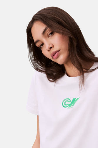 T-shirt blanc à manches courtes de Calvin Klein, avec un logo vert sur la poitrine.