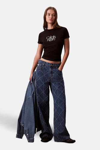 T-shirt noir à manches courtes de Calvin Klein, avec un logo blanc sur la poitrine, associé à des jeans à carreaux.