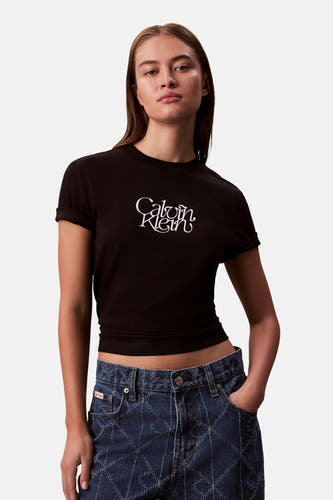 T-shirt noir à manches courtes de Calvin Klein, porté avec un jean bleu imprimé.