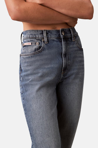 Middenblauwe mom jeans van Calvin Klein, met zichtbare zakken en knoopsluiting.

