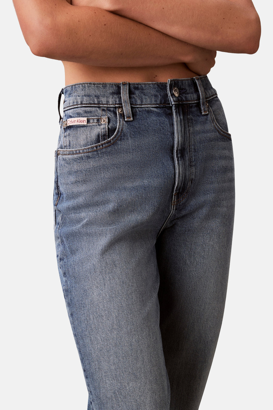 Middenblauwe mom jeans van Calvin Klein, met zichtbare zakken en knoopsluiting.
