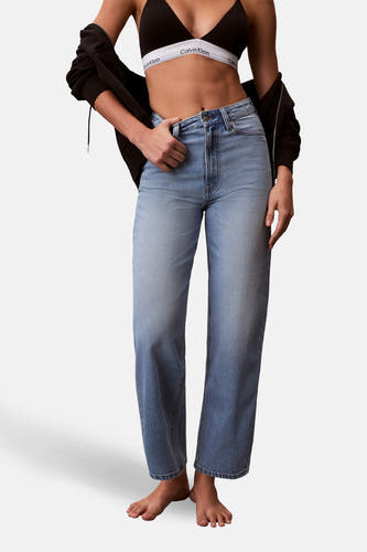 Jeans coupe spéciale en denim bleu clair de Calvin Klein, avec un mannequin dans un haut et une veste noirs, debout.