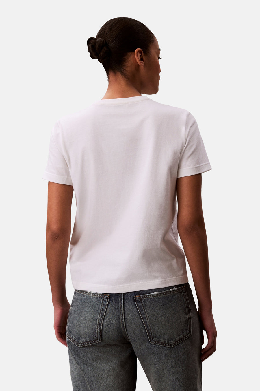 T-shirt blanc Calvin Klein, vu de dos, à manches courtes et associé à un jean bleu.