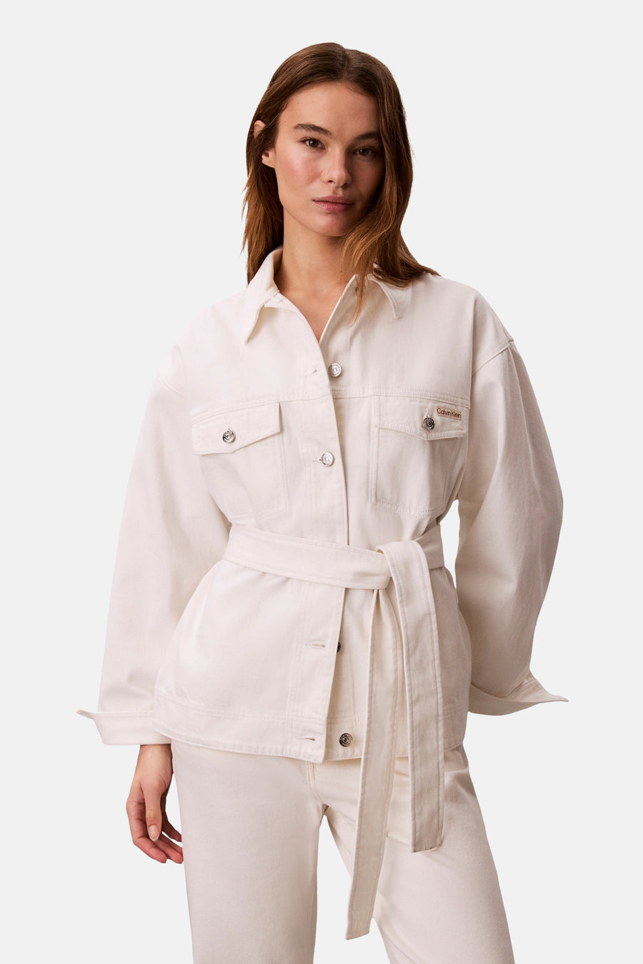 Kort off-white denim jack van Calvin Klein met lange mouwen, knoopsluiting en riem.