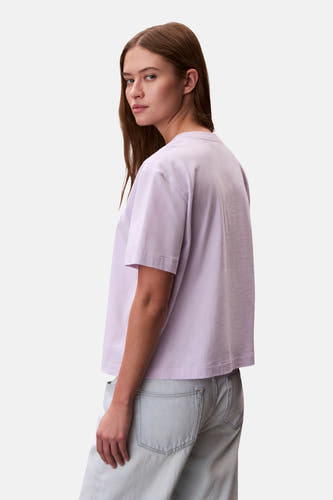T-shirt à manches courtes violet de Calvin Klein, coupe décontractée, associé à un jean bleu clair.