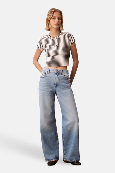 T-shirt multicolore Calvin Klein, à manches courtes et à motif rayé, porté avec un jean ample.
