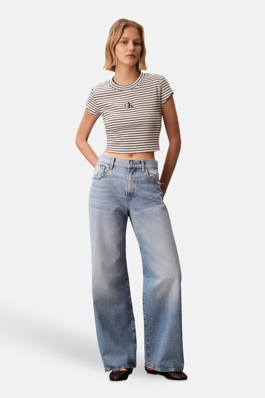 T-shirt multicolore Calvin Klein, à manches courtes et à motif rayé, porté avec un jean ample.