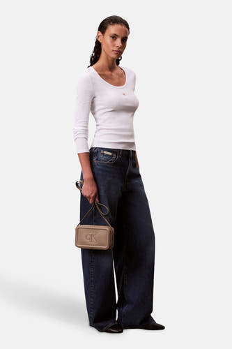 Veste épaules brune Calvin Klein, portée par un modèle avec un t-shirt blanc et des jeans larges.