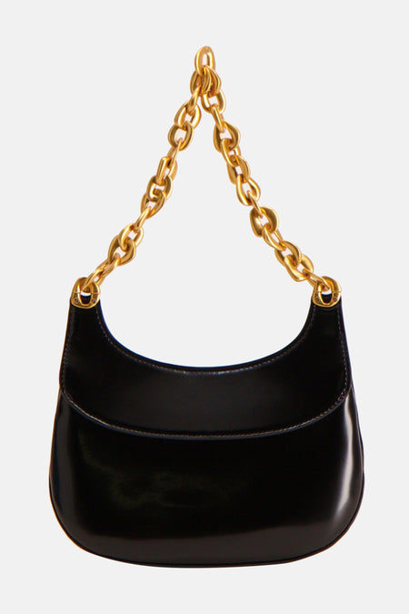 Zwarte lakleren schoudertas met gouden ketting.
